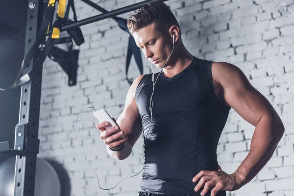 Hombre atlético usando teléfono inteligente - foto de stock