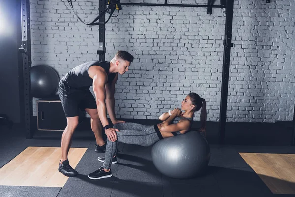 Trainer helping woman work out — Stock Photo