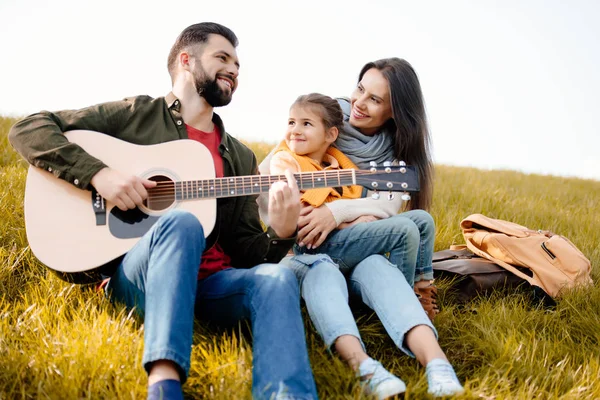 Famille relaxante sur une colline herbeuse — Photo de stock