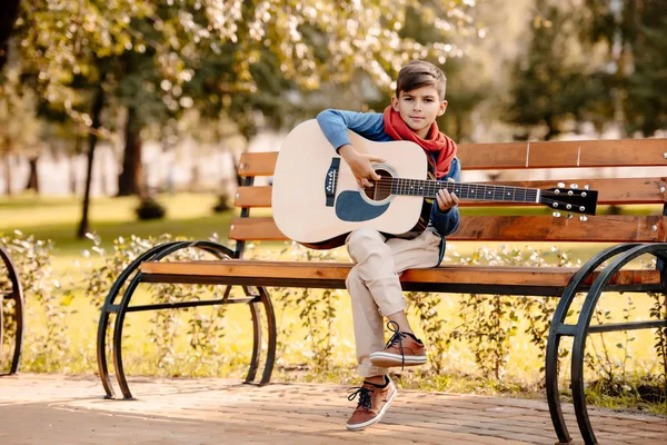 Мальчик с гитарой в парке — стоковое фото