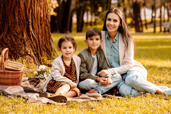 Mamá y niños en manta de picnic - foto de stock