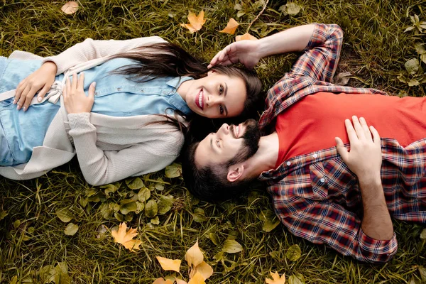 Pareja joven acostada en la hierba - foto de stock