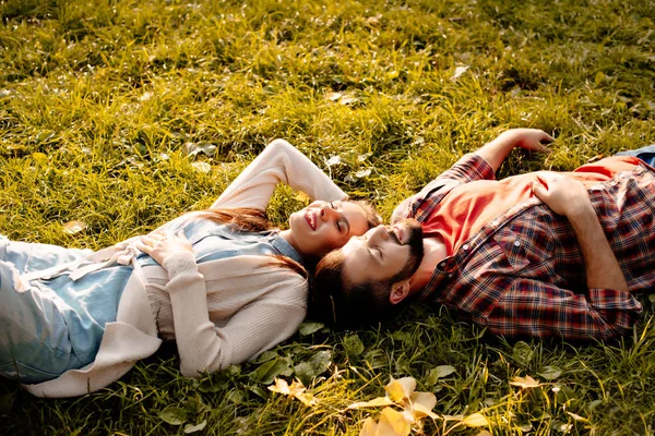 Pareja acostada en la hierba - foto de stock