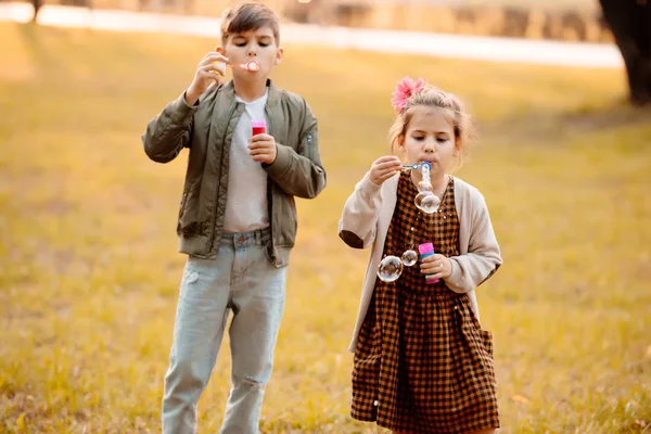 Siblings blowing soap bubbles — Stock Photo