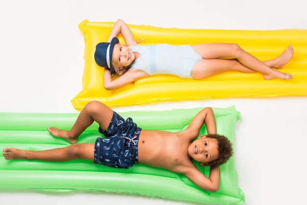 Niños en traje de baño en colchones de natación - foto de stock