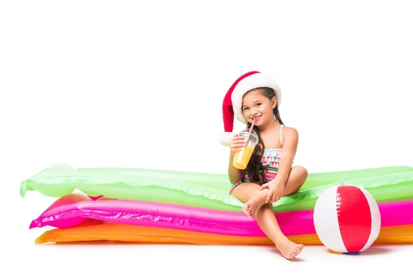 Niño en sombrero de santa con jugo de naranja - foto de stock