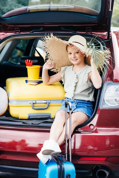 Viajando menina sentado no carro tronco — Fotografia de Stock