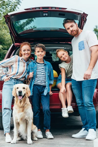 Família com cão de pé ao lado do carro — Fotografia de Stock