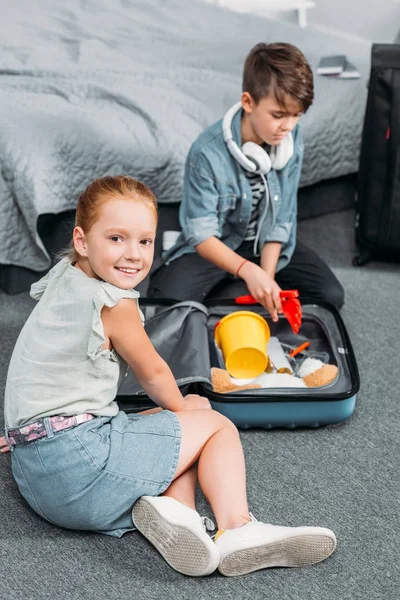 Enfants emballant des vêtements pour le voyage — Photo de stock