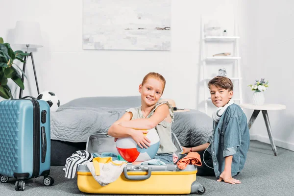 Kids packing clothes for trip — Stock Photo
