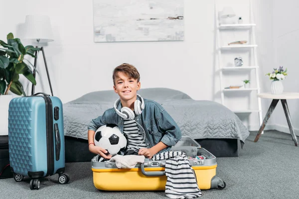 Мальчик, сидящий в чемодане для поездки — стоковое фото