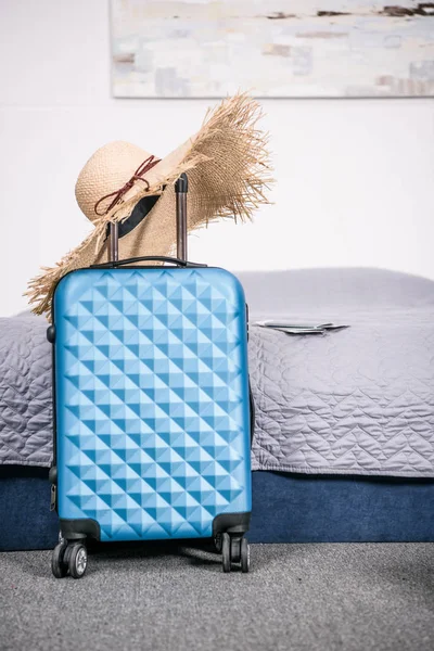 Suitcase with straw hat — Stock Photo