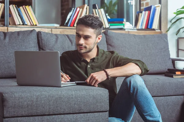 Man with laptop and notebook — Stock Photo