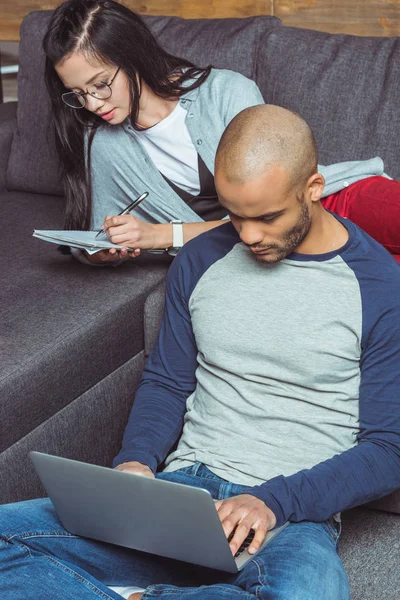 Students with laptop and notebook — Stock Photo