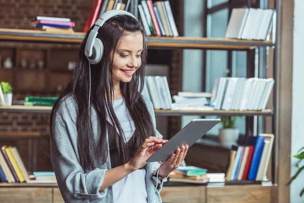 Girl in headphones with digital tablet — Stock Photo