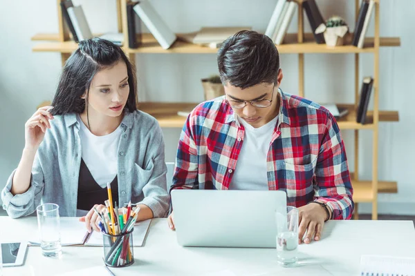 Estudiantes multiétnicos que estudian con portátil - foto de stock