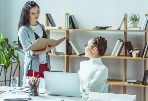 Багатоетнічні студенти з книгою та ноутбуком — Stock Photo