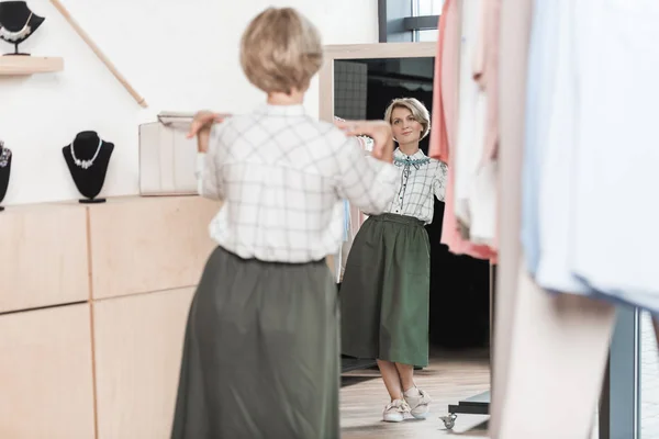 Woman trying on necklace at store — Stock Photo