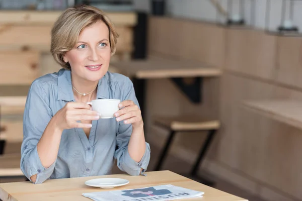 Mujer tomando café en la cafetería - foto de stock