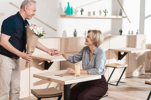 Homme présentant bouquet de fleurs à la femme — Photo de stock