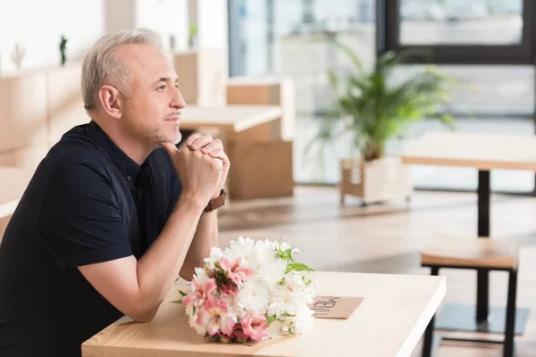 Hombre esperando mujer con flores - foto de stock