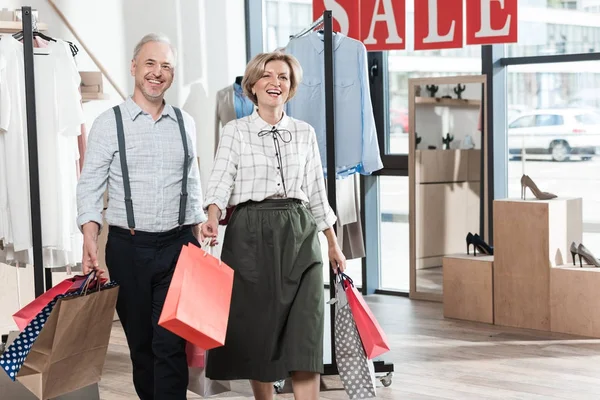 Mulher e homem sorrindo com sacos de compras — Fotografia de Stock