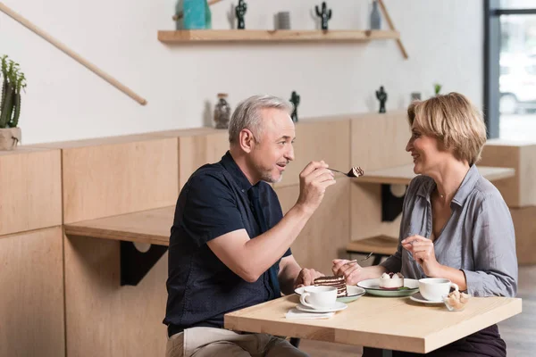 Pareja comiendo dulces en la cafetería - foto de stock