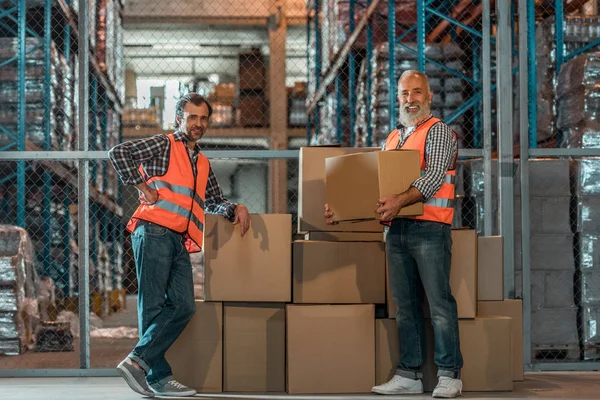 Trabajadores de almacén con cajas - foto de stock