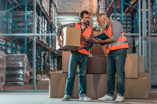 Trabalhadores de armazém com área de transferência — Fotografia de Stock