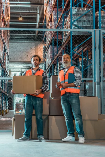 Trabajadores de almacén con portapapeles - foto de stock