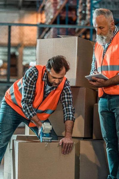 Trabajadores de almacén con tableta digital - foto de stock