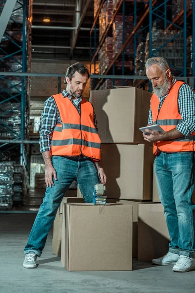 Trabajadores de almacén con tableta digital - foto de stock