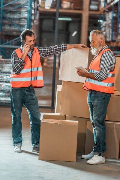 Warehouse workers with digital devices — Stock Photo