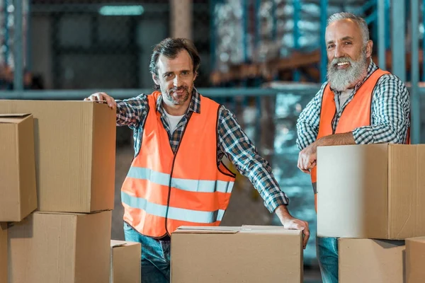 Trabajadores de almacén con cajas - foto de stock