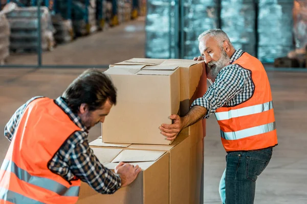 Рабочие склада перевозят коробки — стоковое фото