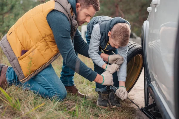 Father and son changing car wheel — Stock Photo