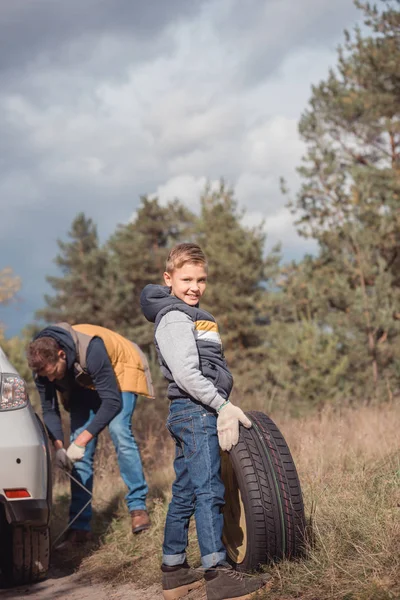 Pai e filho mudando roda do carro — Fotografia de Stock