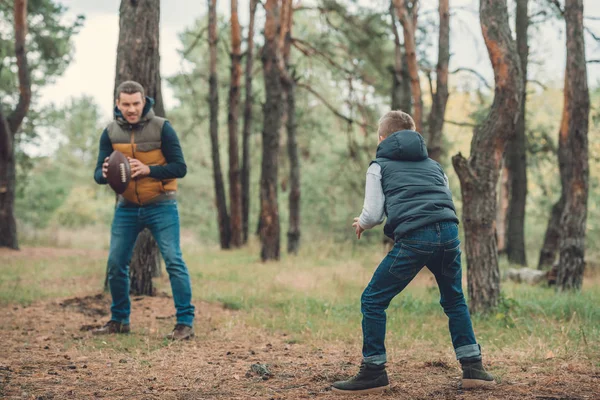 Father and son playing with ball in forest — Stock Photo