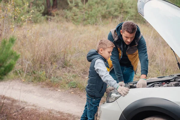Батько і син ремонтують автомобіль — стокове фото