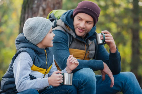 Padre e hijo bebiendo té en el bosque - foto de stock