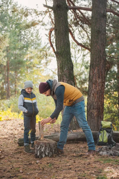 Padre e hijo cortando leña - foto de stock