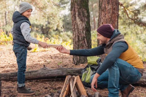 Father and son kindling bonfire — Stock Photo