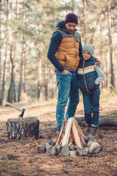 Father and son looking at campfire — Stock Photo