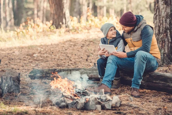 Father and son with digital tablet in forest — Stock Photo