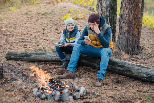 Padre e figlio con dispositivi nella foresta — Foto stock