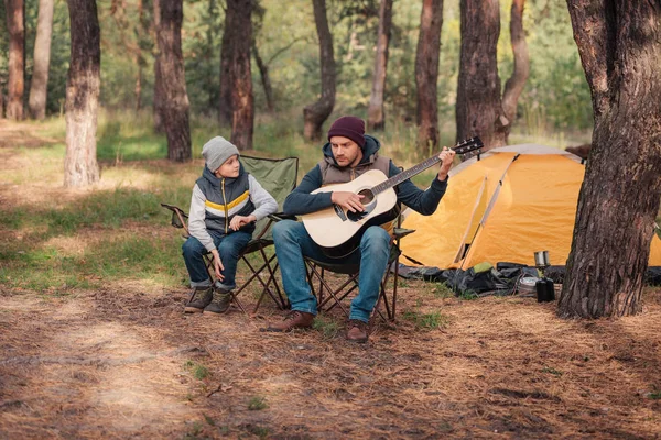 Батько і син з гітарою в лісі — стокове фото