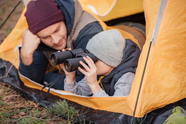 Pai e filho com binóculos na tenda — Fotografia de Stock