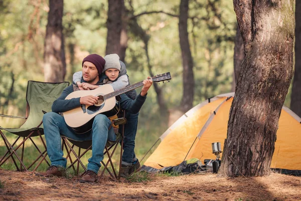 Padre e hijo con guitarra en el bosque - foto de stock