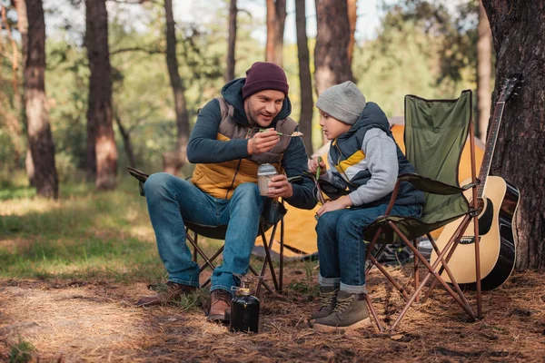 Père et fils manger dans la forêt — Photo de stock