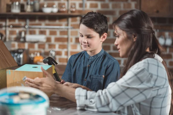 Mère et fils construisant nichoir avec marteau — Photo de stock